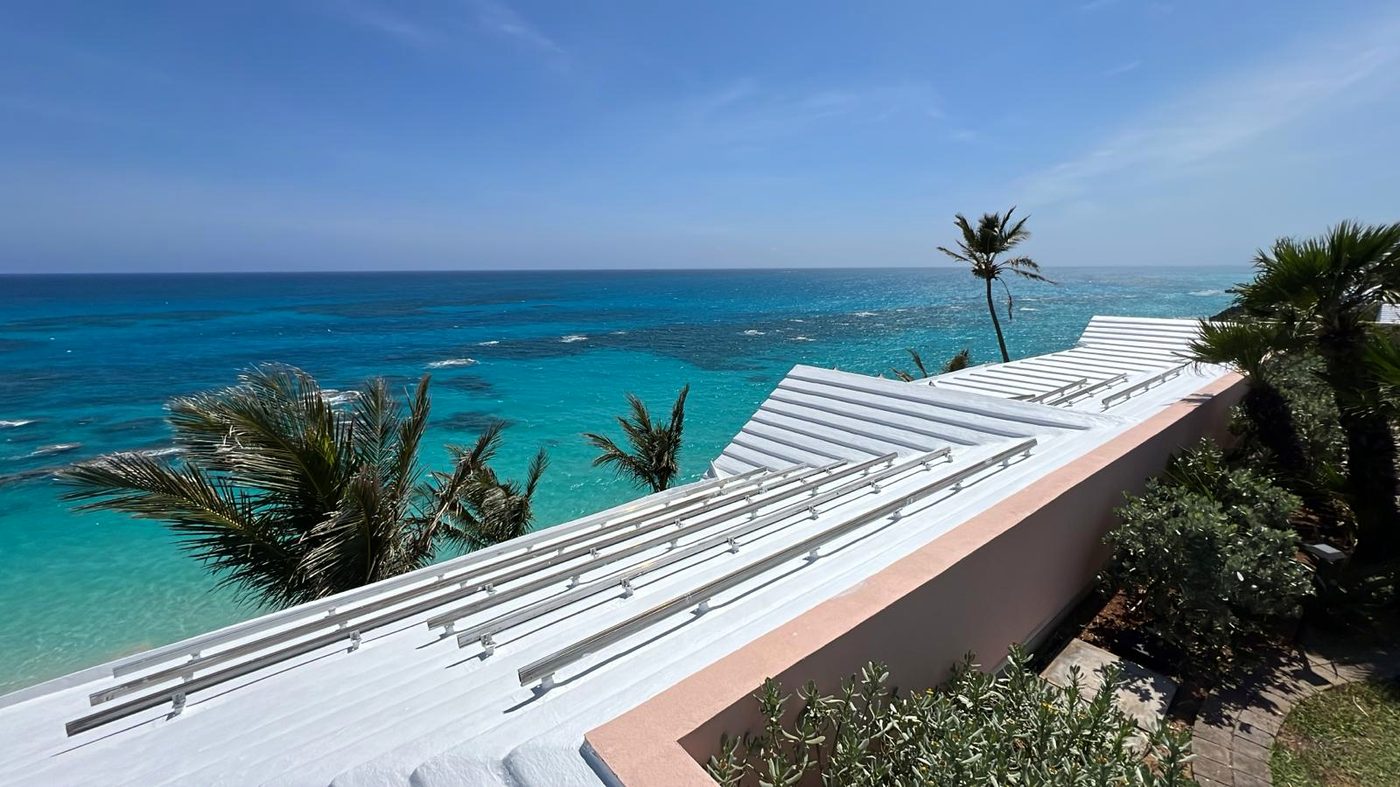 A freshly coated commercial roof and parapet above turquoise water
